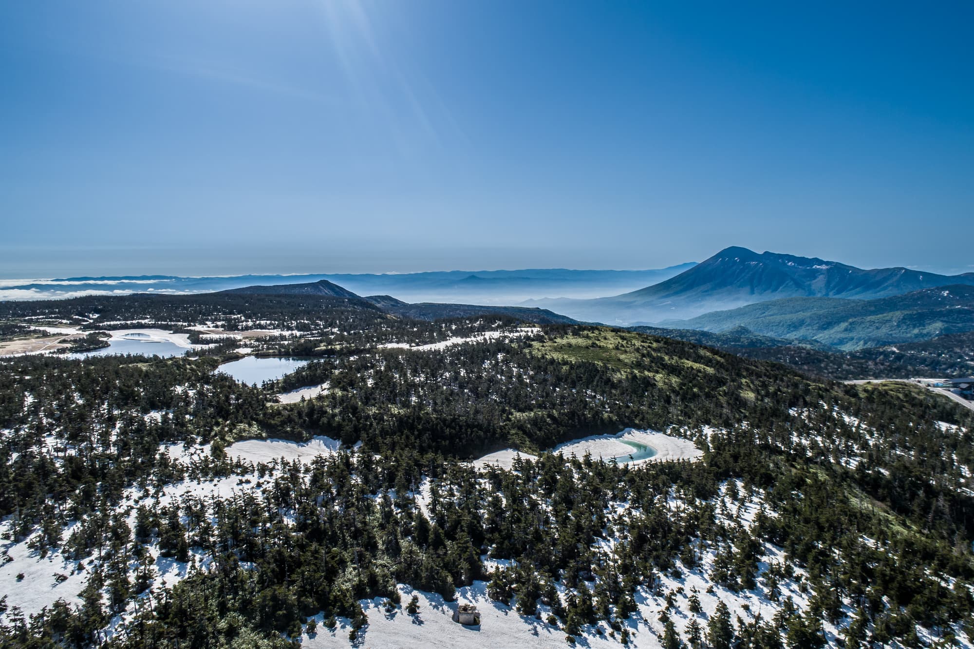 八幡平山頂の沼と岩手山の空撮