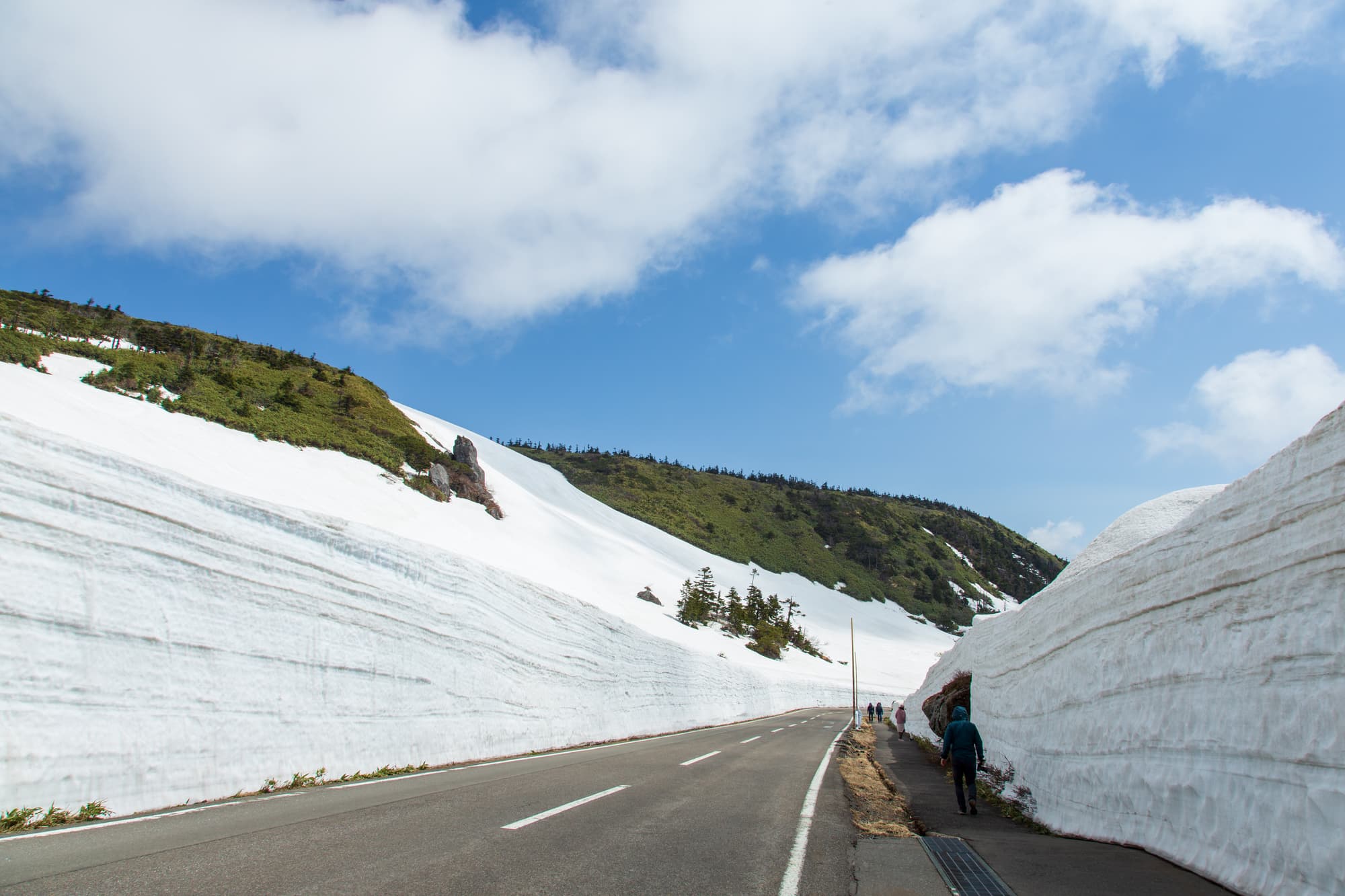 雪の壁のあいだを通る春の道